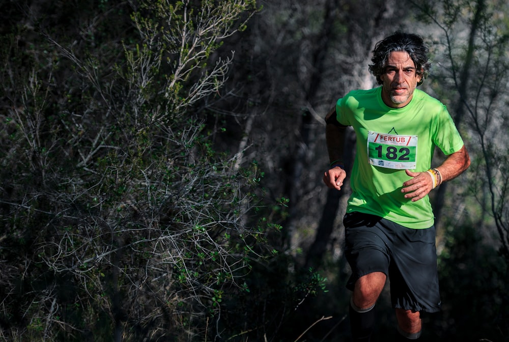 man in green t-shirt running with 182 numbered shirt