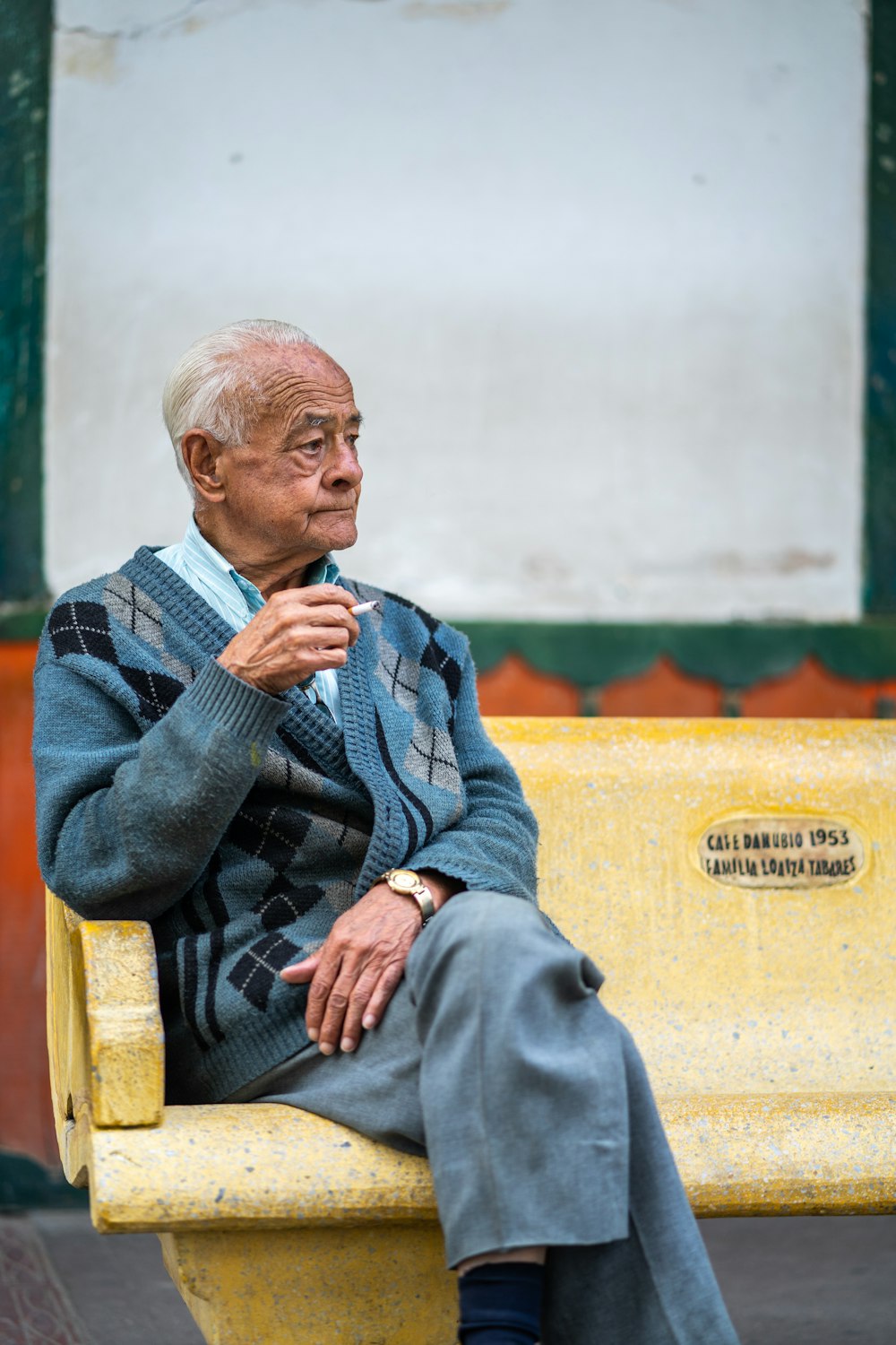 uomo che si siede sulla panchina mentre fuma