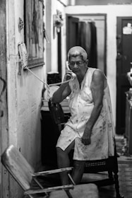 grayscale photography of woman using telephone