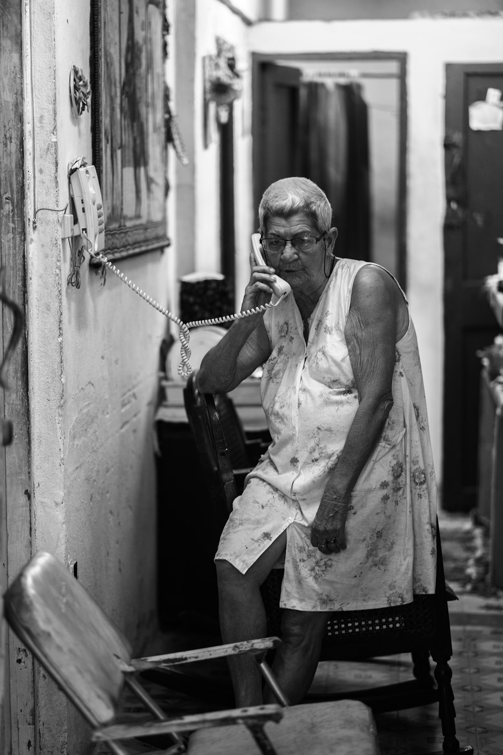 grayscale photography of woman using telephone