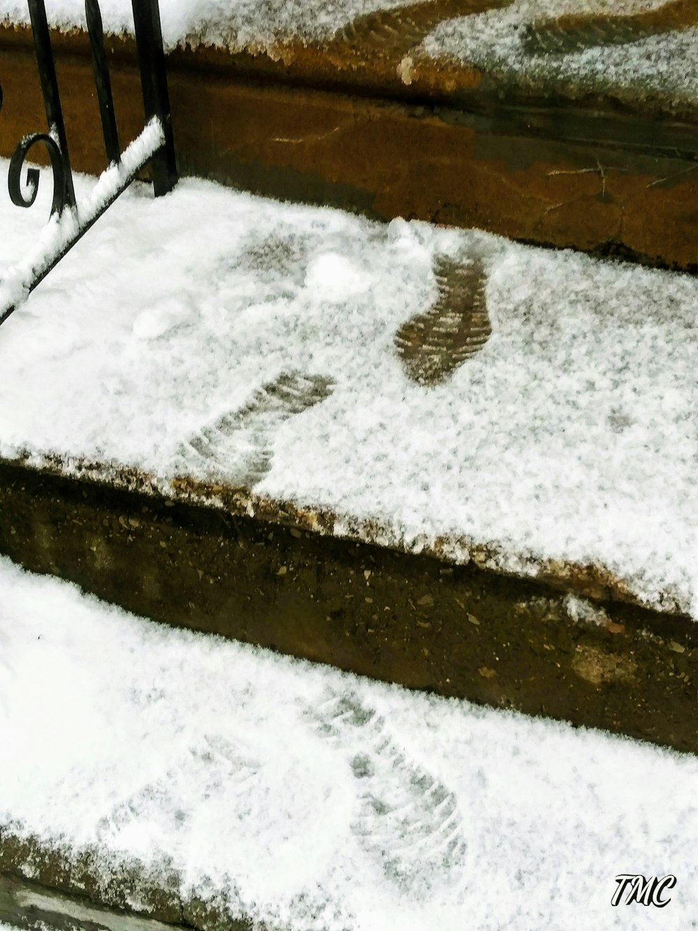 a bench covered in snow next to steps