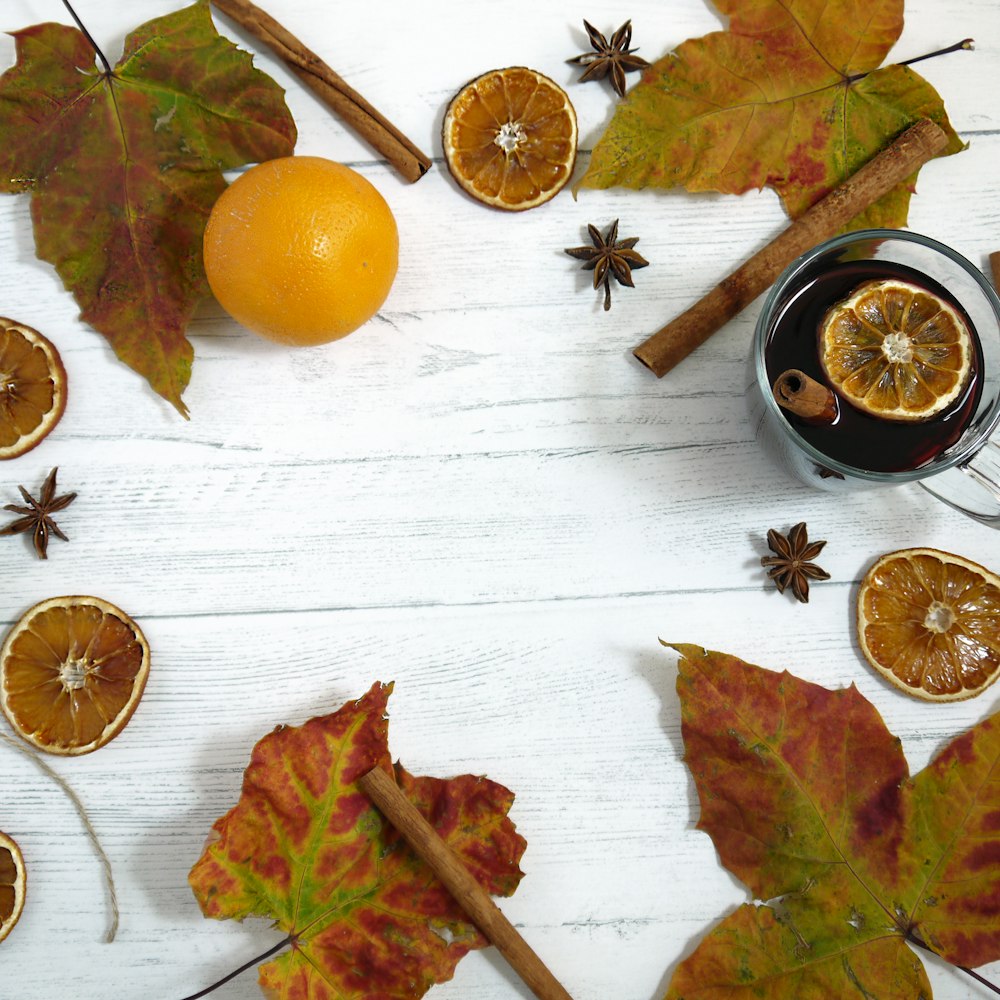 fruta laranja ao lado de copo transparente cheio de líquido preto