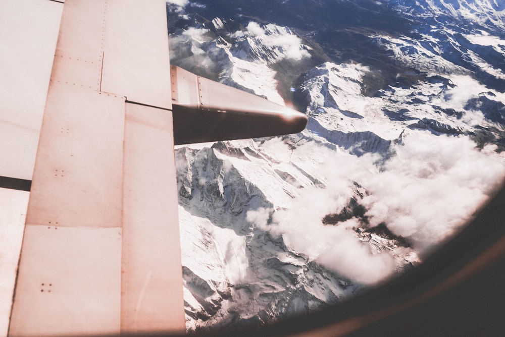 snow capped mountain range viewed from plane window