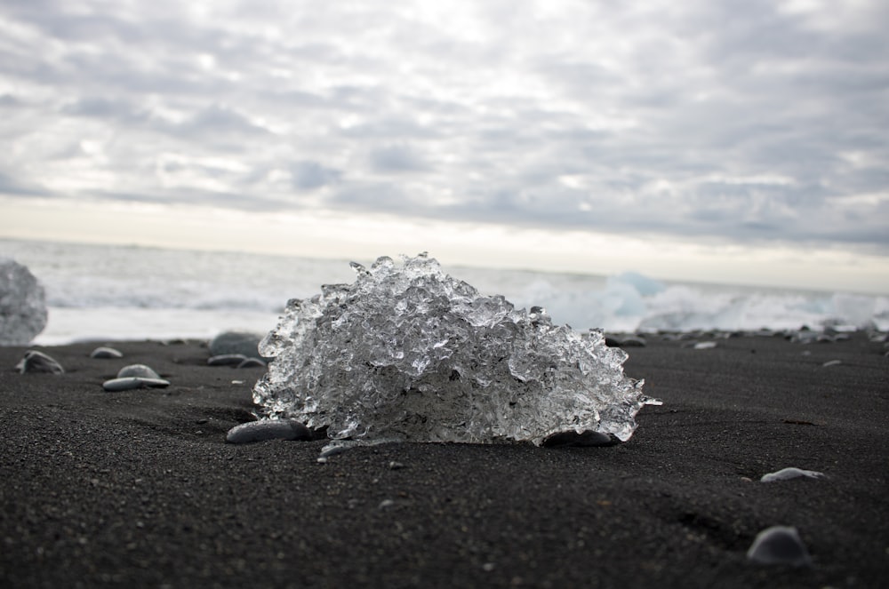 a close up of ice on a beach near the ocean