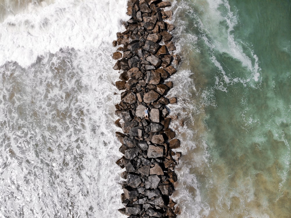 brown rocks between body of water