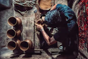 An artisan at work shaping clay on a potter’s wheel surrounded by vibrant glazes.