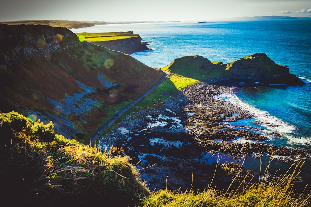 body of water beside cliff \