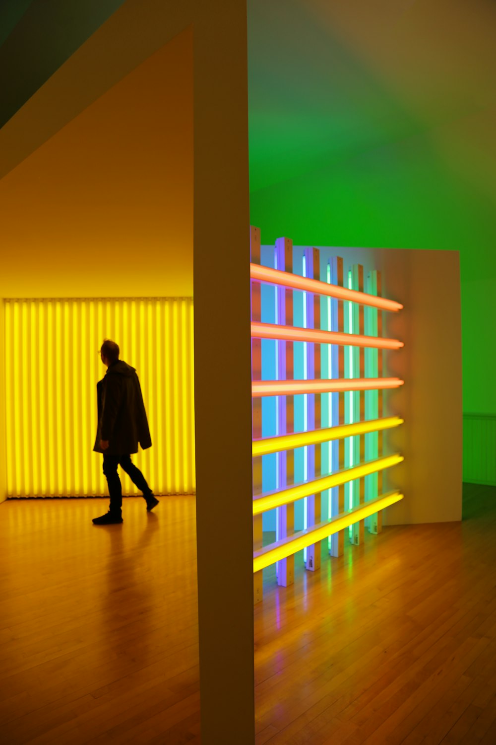 a person walking in a room with a neon wall