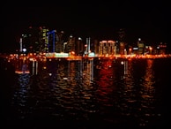 A city skyline at night illuminated with vibrant blue and green lights reflecting technology and finance.