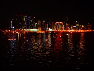 A city skyline at night illuminated with vibrant blue and green lights reflecting technology and finance.
