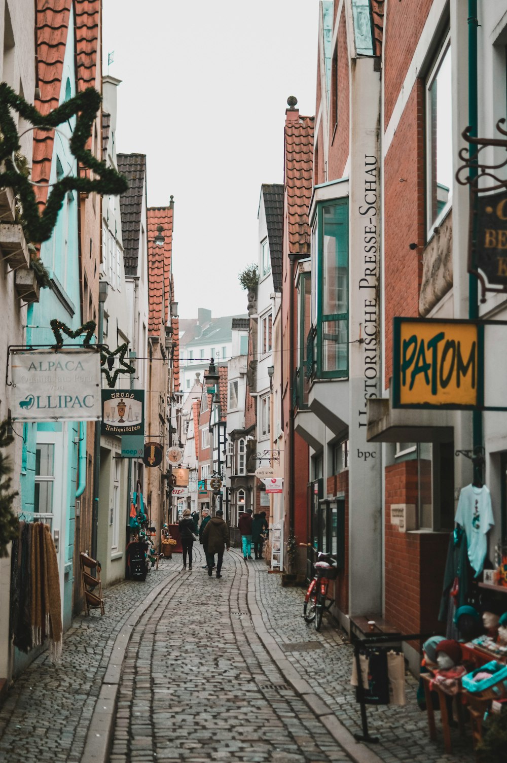 few people walking on pathway between buildings