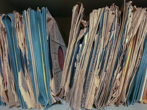 a close up of a bunch of papers on a shelf