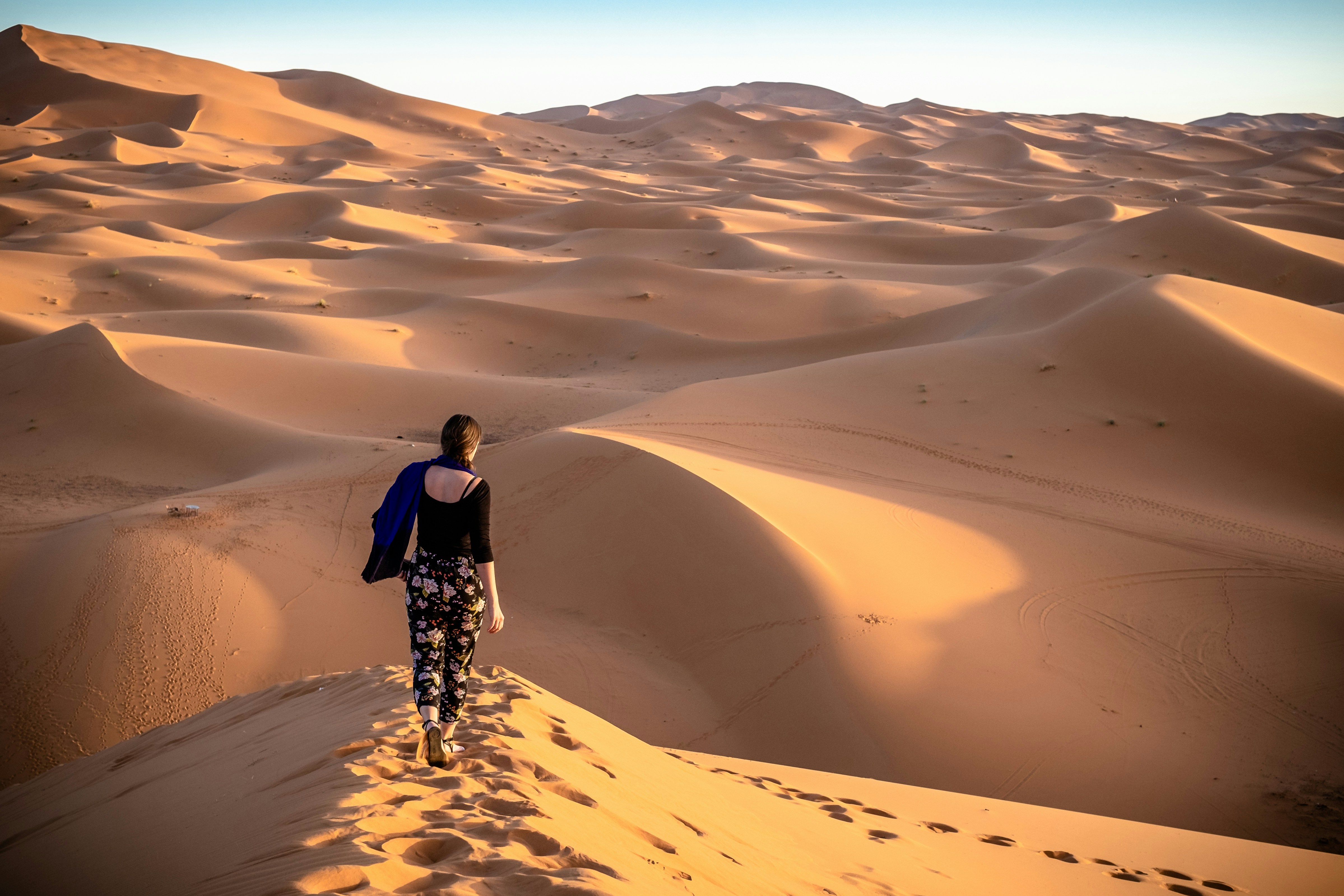 Woman walking on desert during daytime