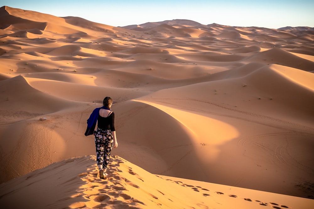 woman walking on desert during daytime