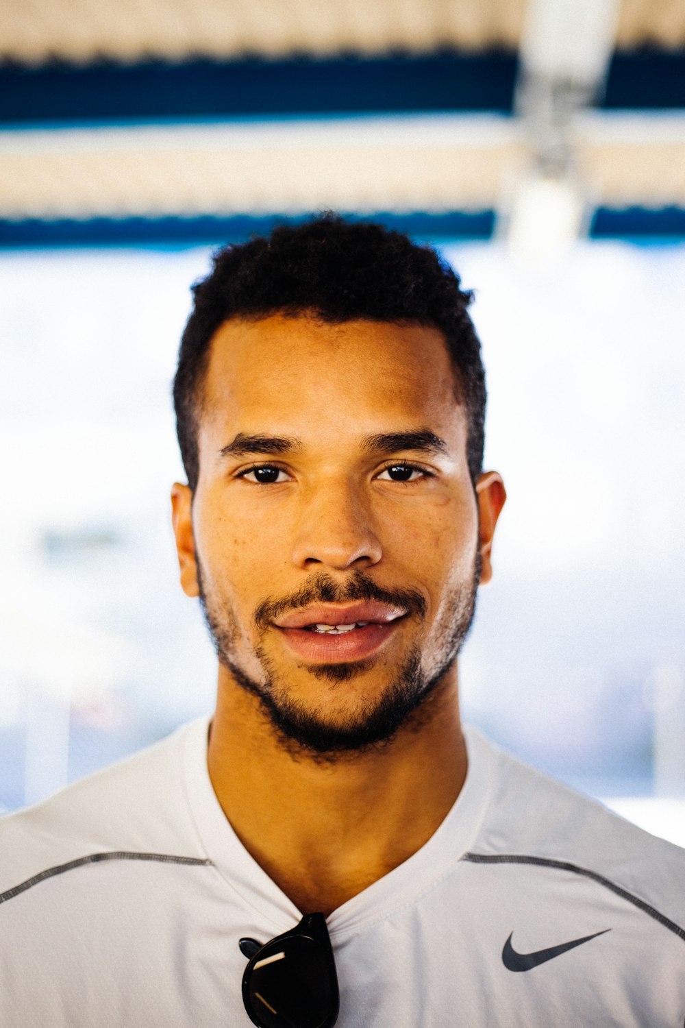 smiling man in white Nike shirt