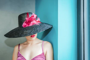 woman wearing pink camitop and black straw hat