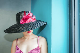 woman wearing pink camitop and black straw hat