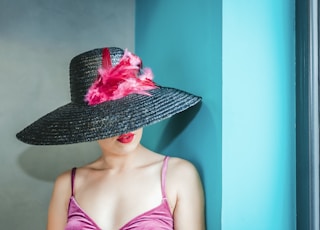 woman wearing pink camitop and black straw hat