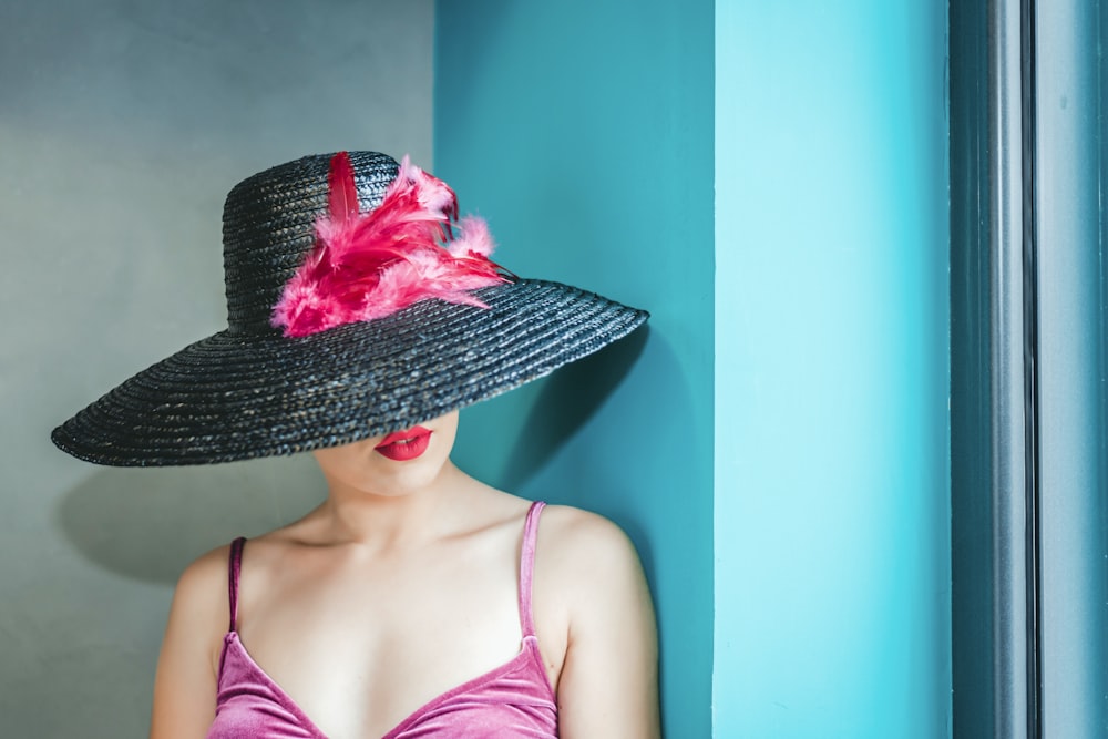woman wearing pink camitop and black straw hat