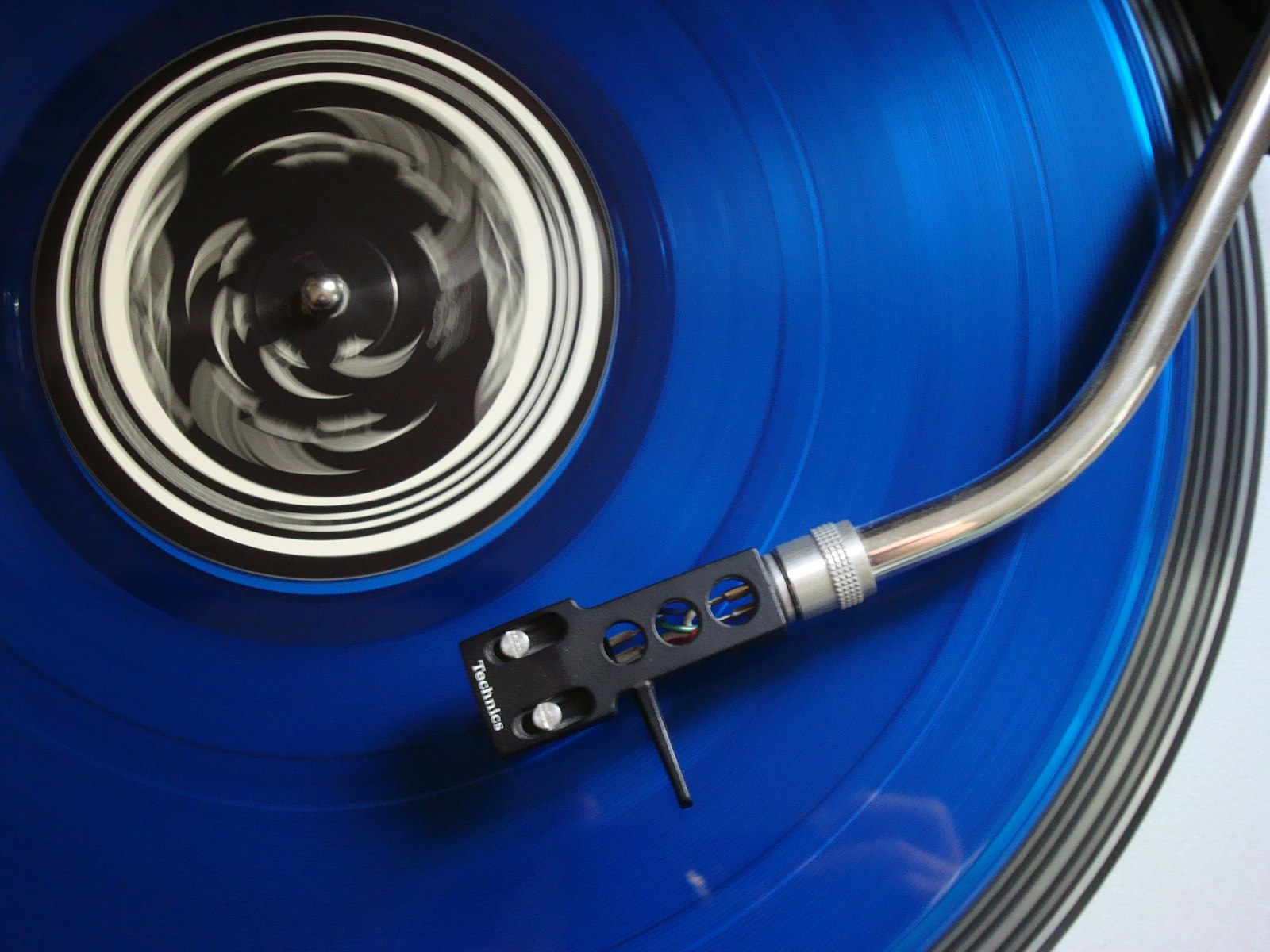 Un disque bleu en rotation sur une platine, vu de près
