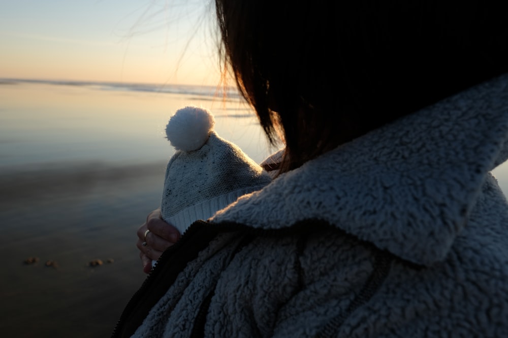 woman with baby stands on beach