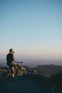 man riding on bicycle while standing on peak