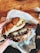 Close-up of a juicy smash picaña burger with melted cheese and fresh toppings on a rustic wooden table.