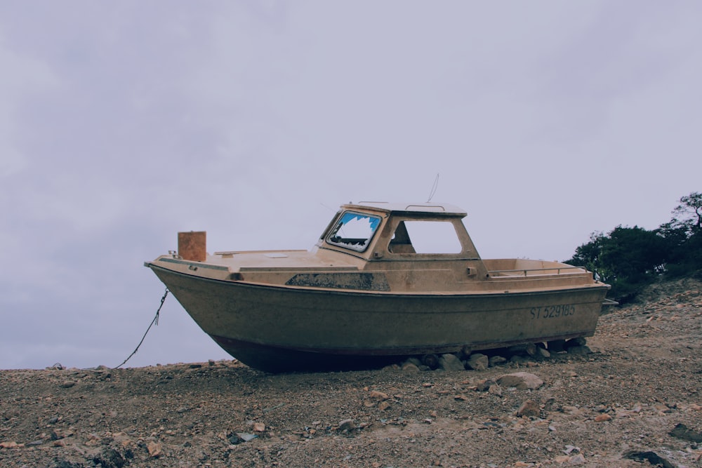 abandoned white boat on shore