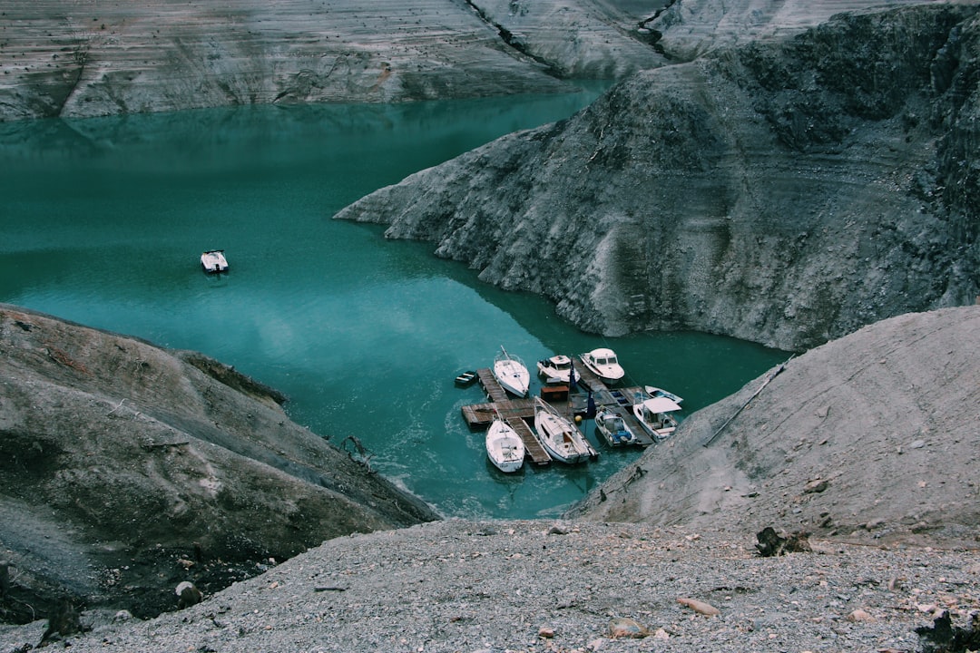 several boats next to docks and mountains during daytime