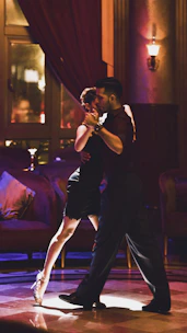 Claudia leading a passionate tango class in a sunlit Florentine studio.