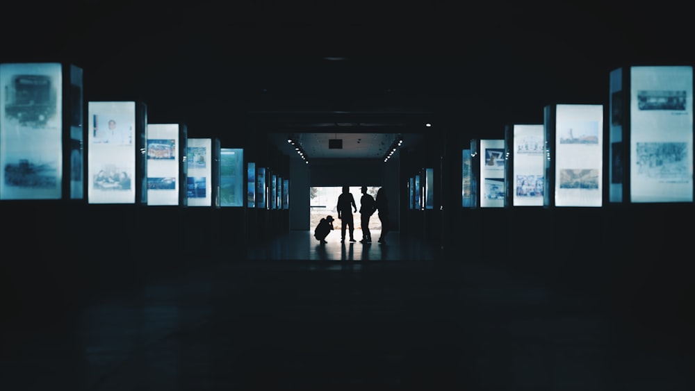 silhouette photography of three person standing in building interior