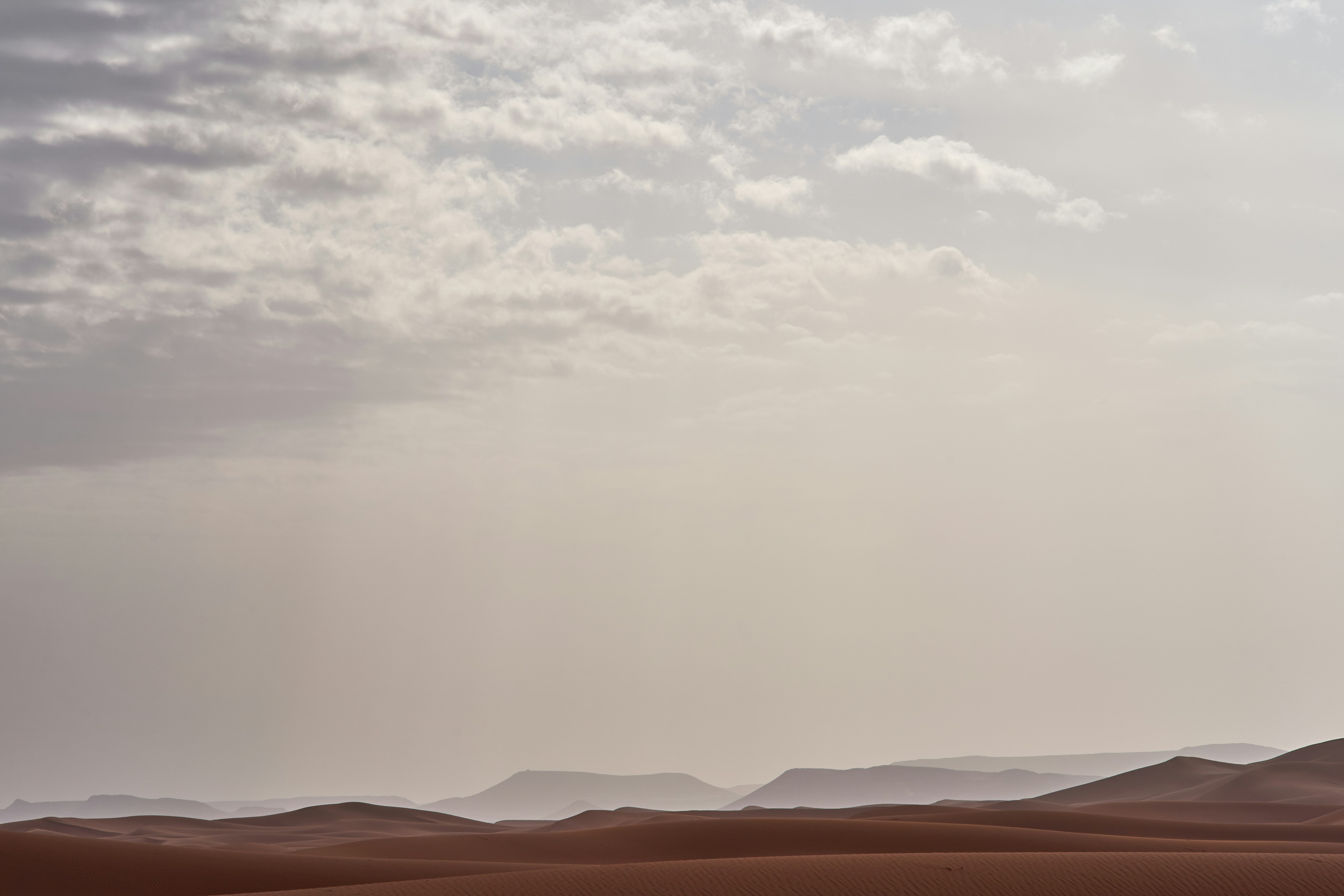 brown desert under cloudy sky during daytime