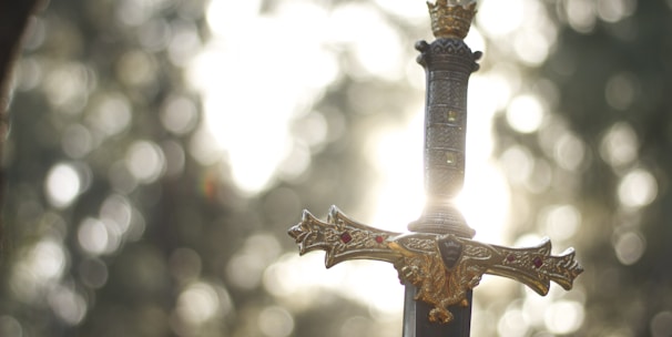 close-up photography of gold-colored and black sword