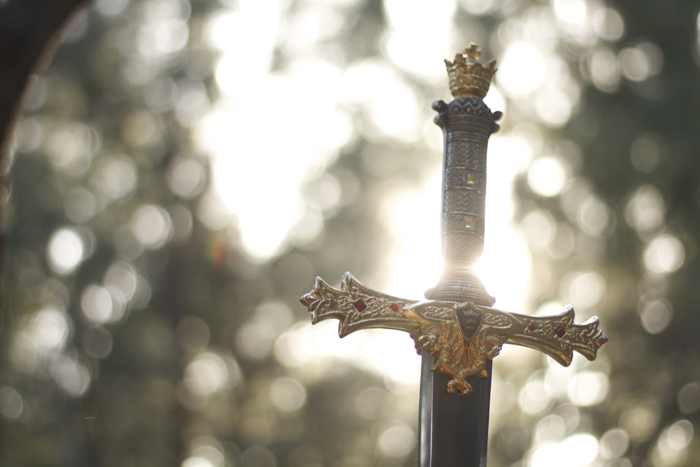 close-up photography of gold-colored and black sword