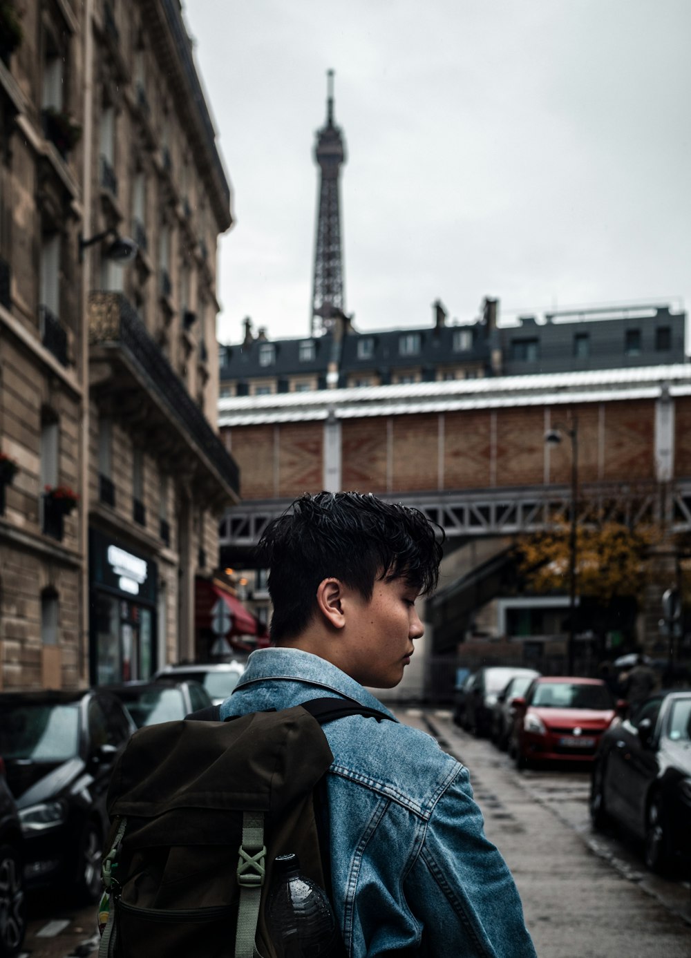 man wearing blue jacket near the building