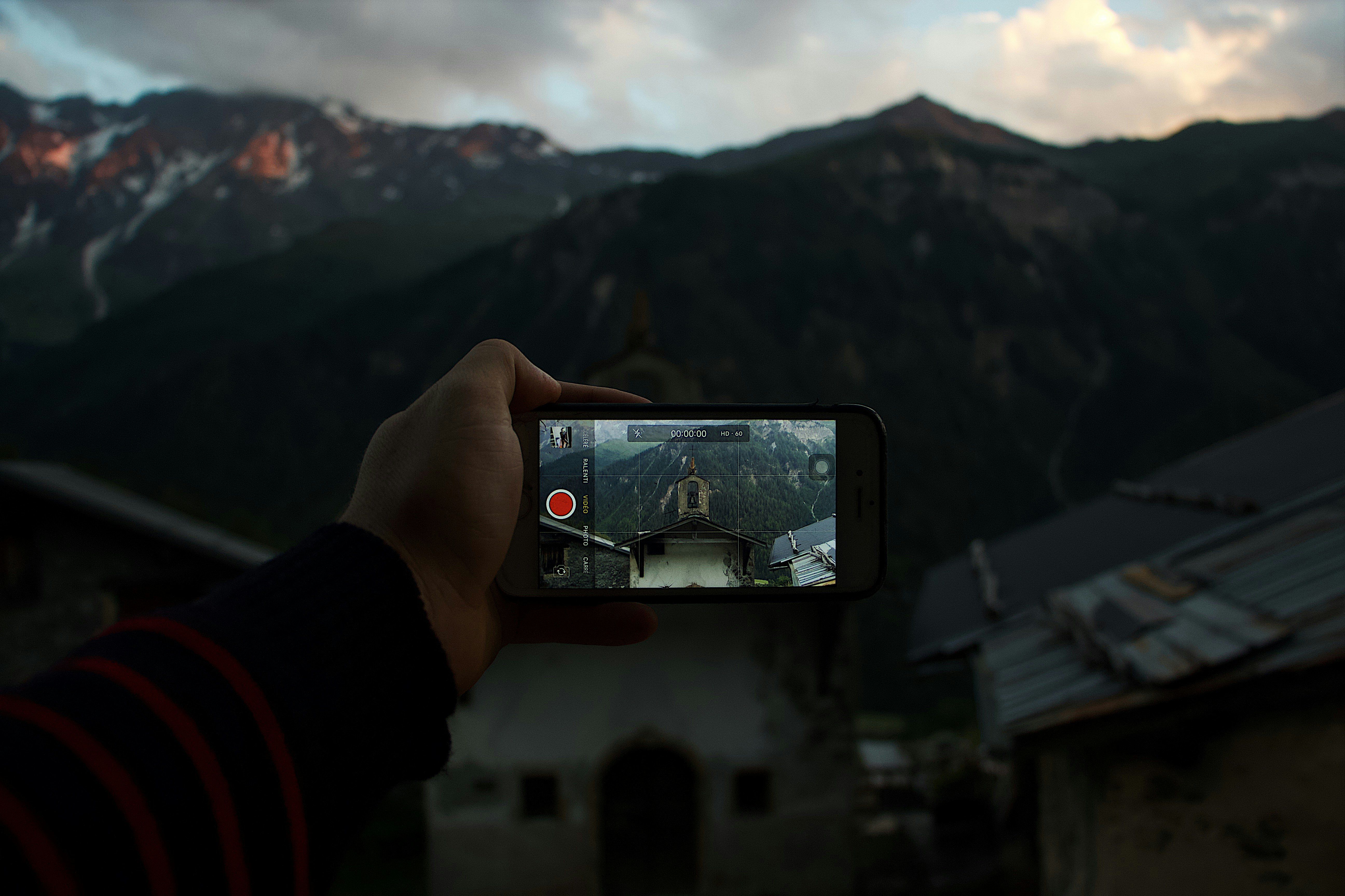 person taking photo of a mountain