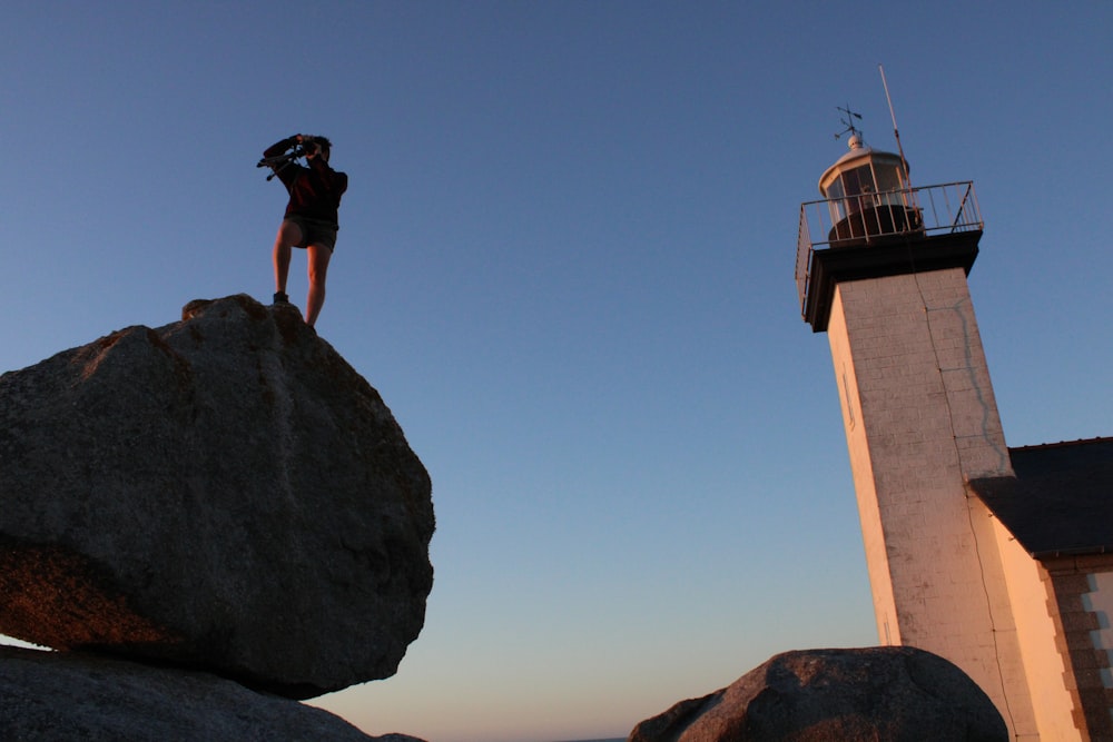 person standing on gray rock