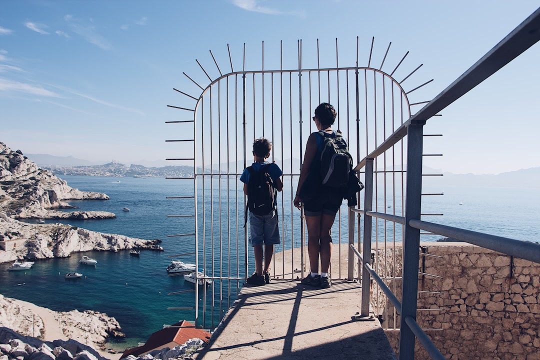 two persons standing on front of white gate