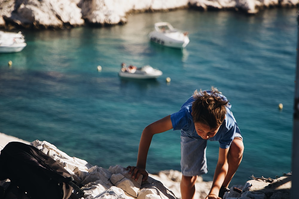 boy climbing on rock