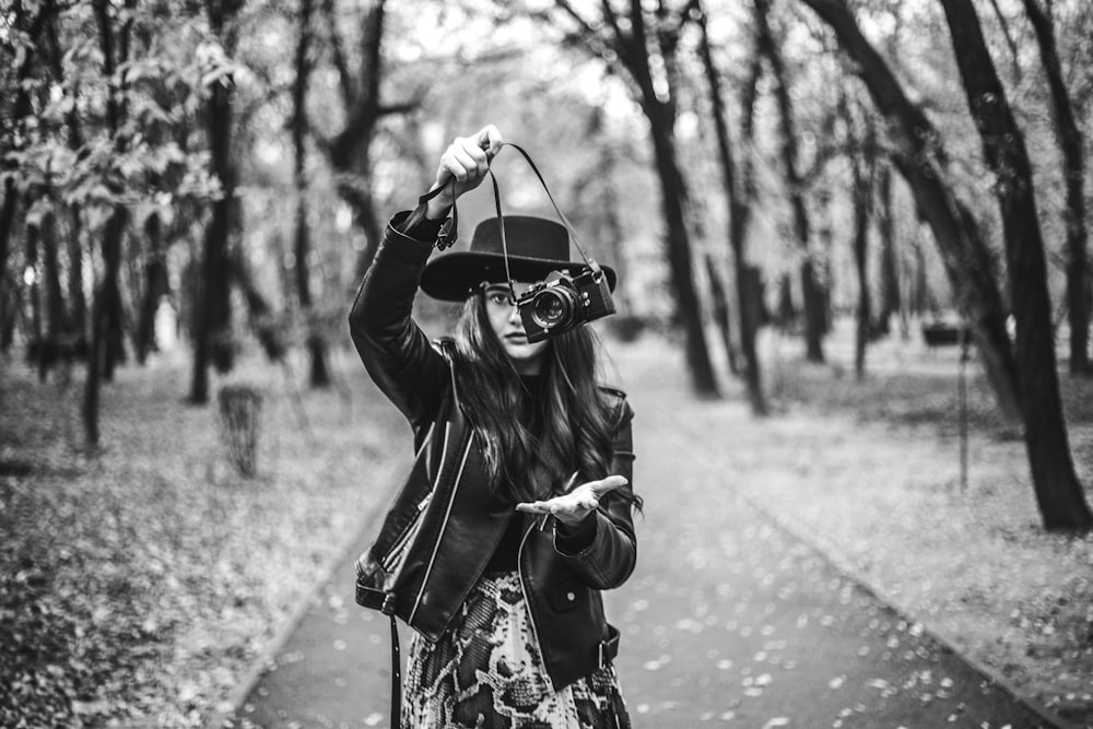 grayscale photography of woman holding camera