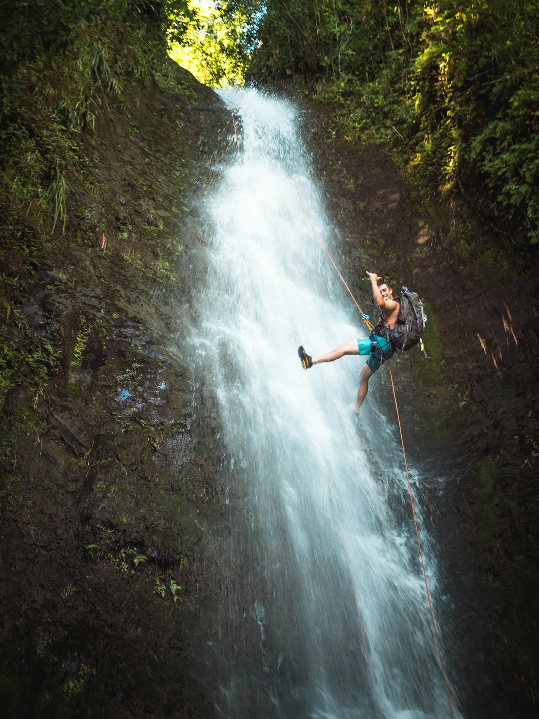 man climbing on waterfalls