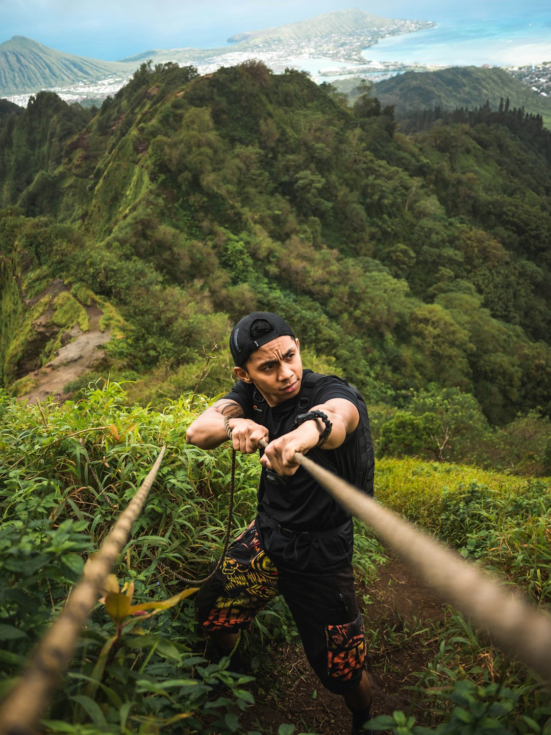 man holds rope at the mountain