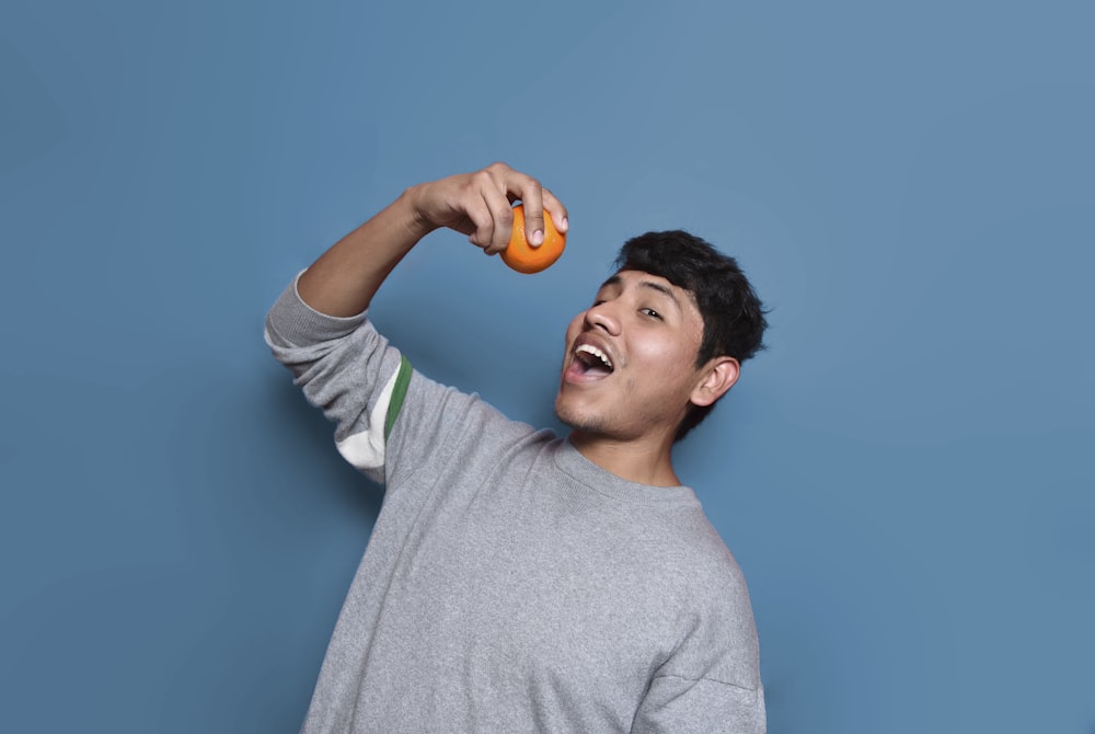 man about to eat orange fruit