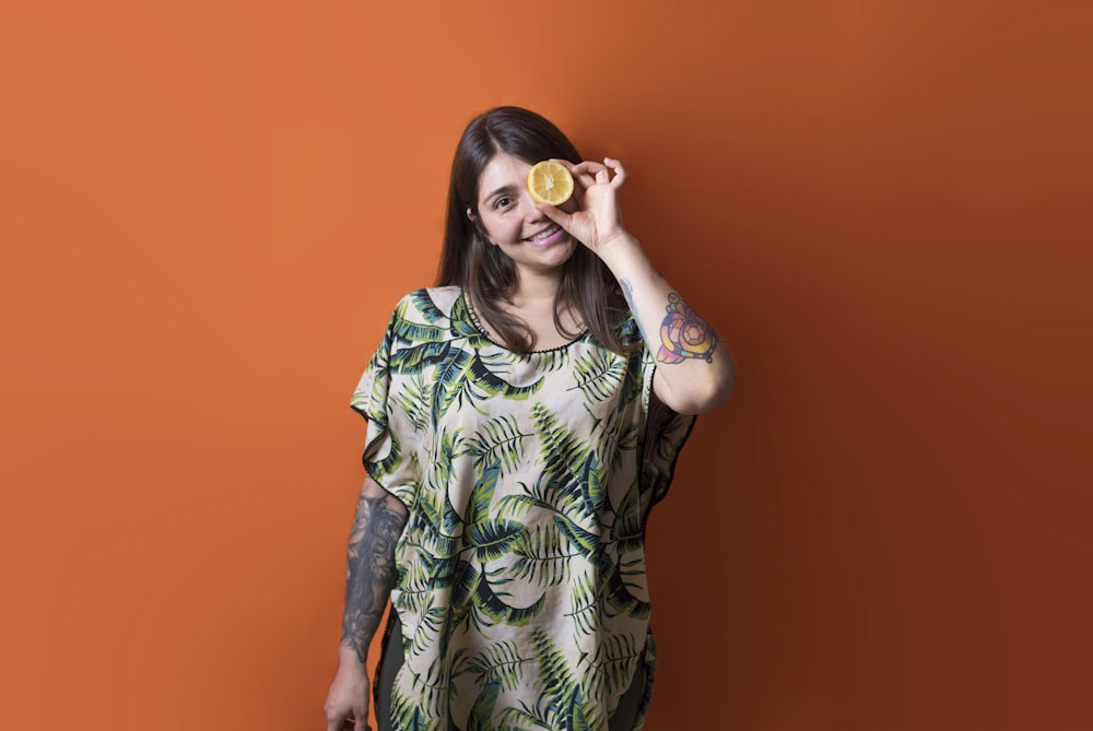 woman putting sliced lemon on eye