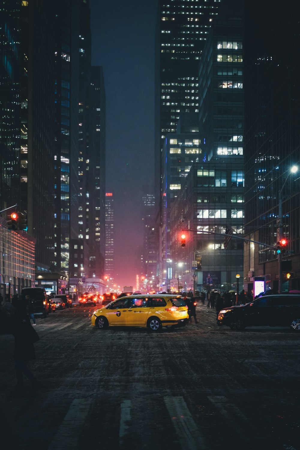 yellow station wagon in the middle of the street during night time