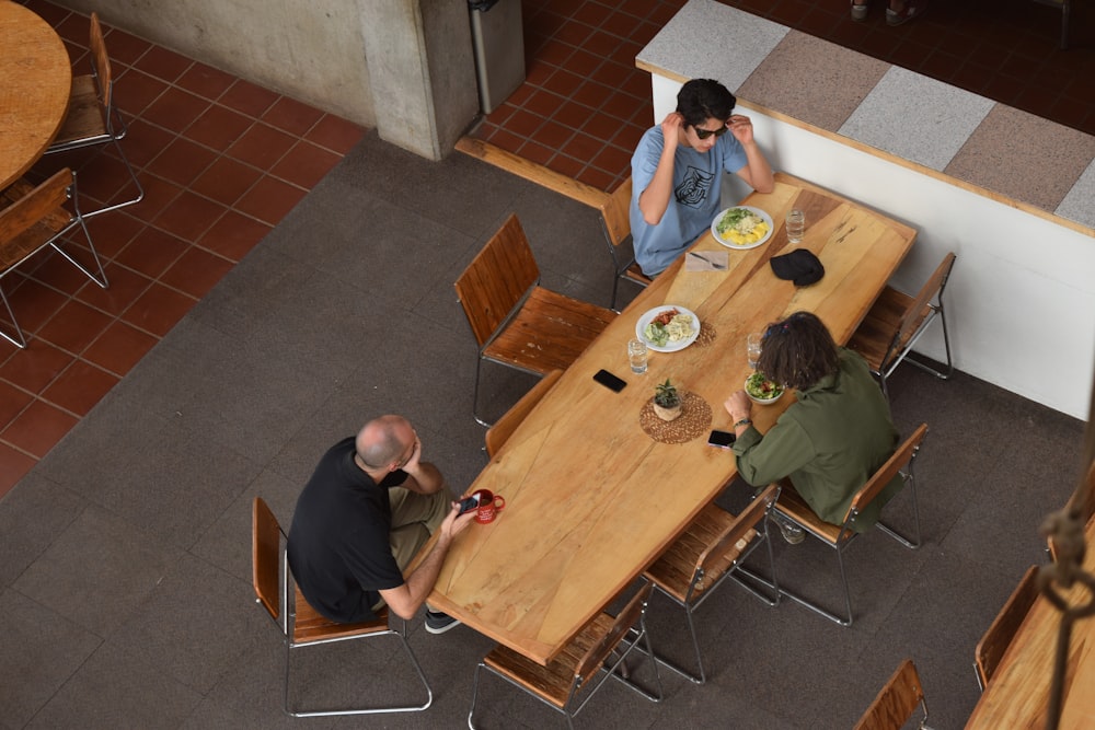 three people sitting at table in aerial shot