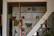Handmade rustic wooden shelf filled with pottery and plants in a sunlit Saudi room.