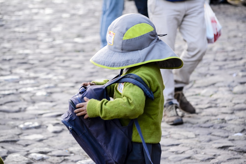 toddler carrying blue backpack