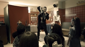 Magician performing a trick with bright props in front of an excited crowd