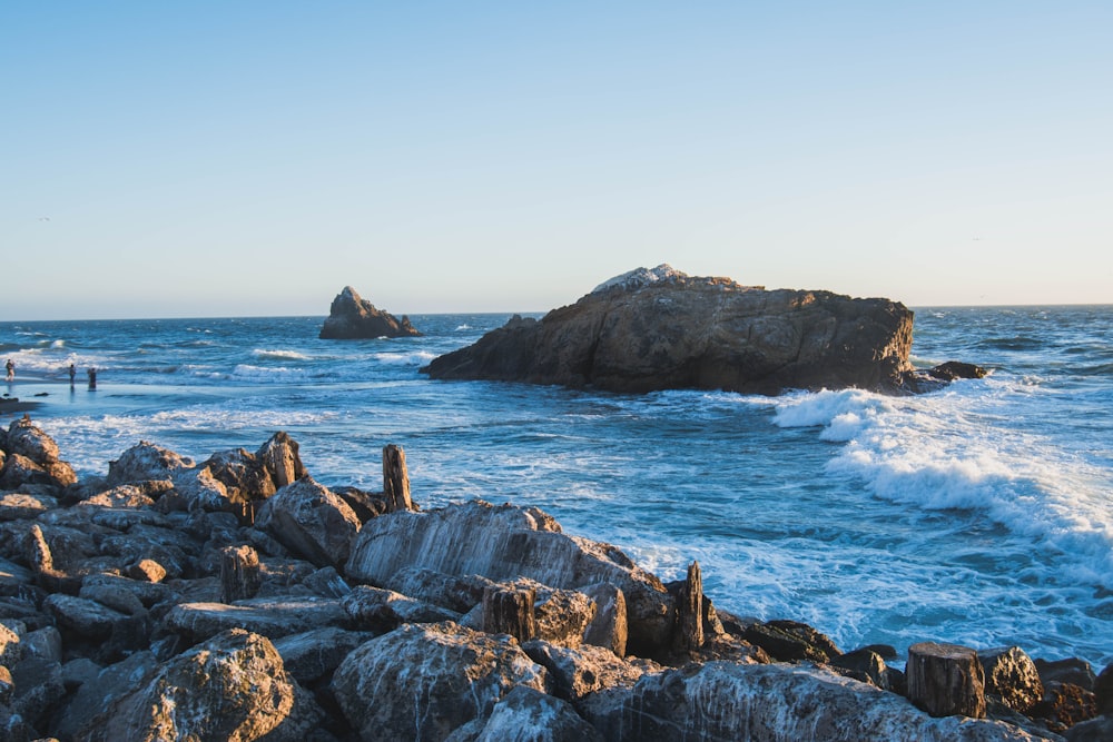 brown stone on the ocean photography